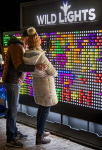 Couple standing in front of a giant light board