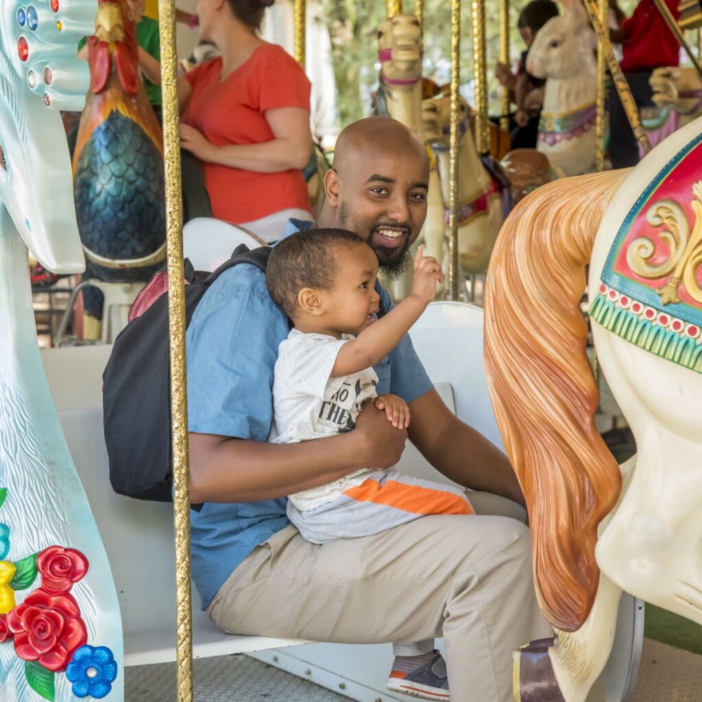 Father and young child riding the carousel