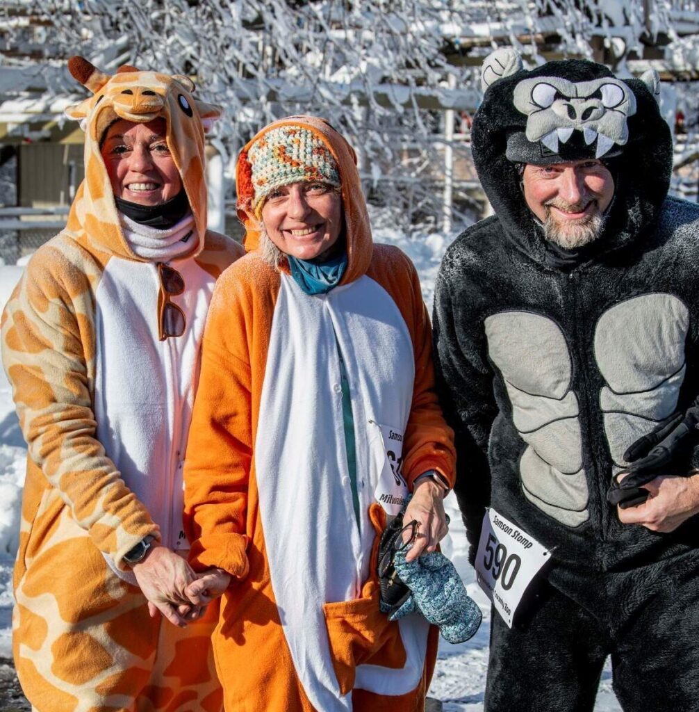 Three adults dressed in animal onesies