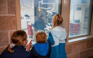 Children looking in the window of a treatment room