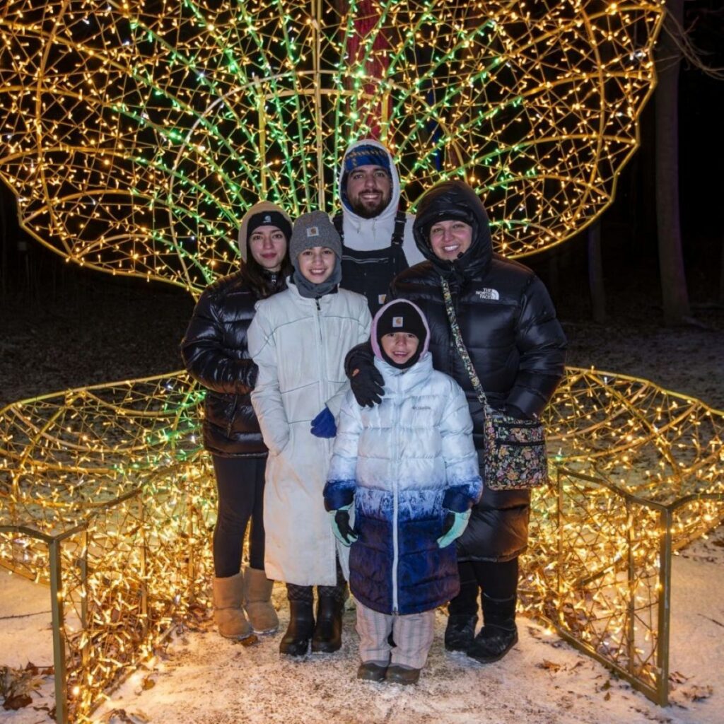 Family standing in front of an oversized illuminated clamshell